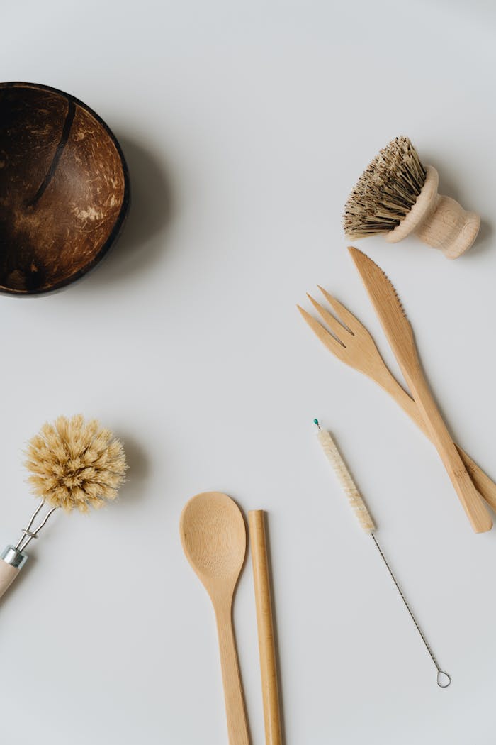 Artful flat lay of wooden and coconut kitchenware on a white background.