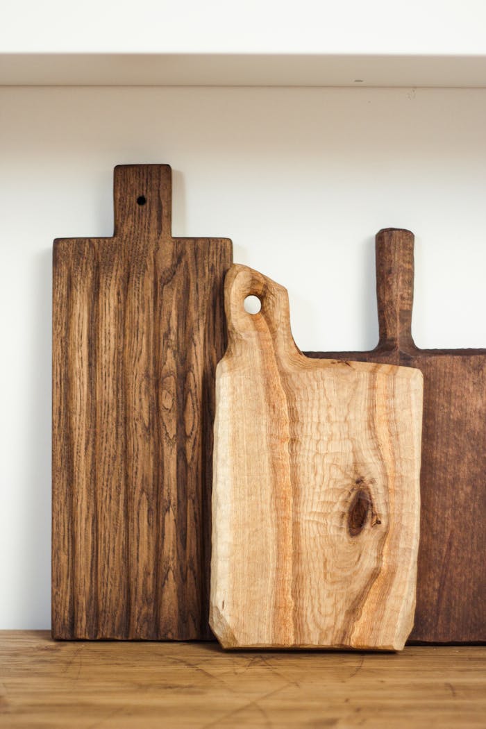 Collection of new wooden cutting boards arranged on table in light modern kitchen